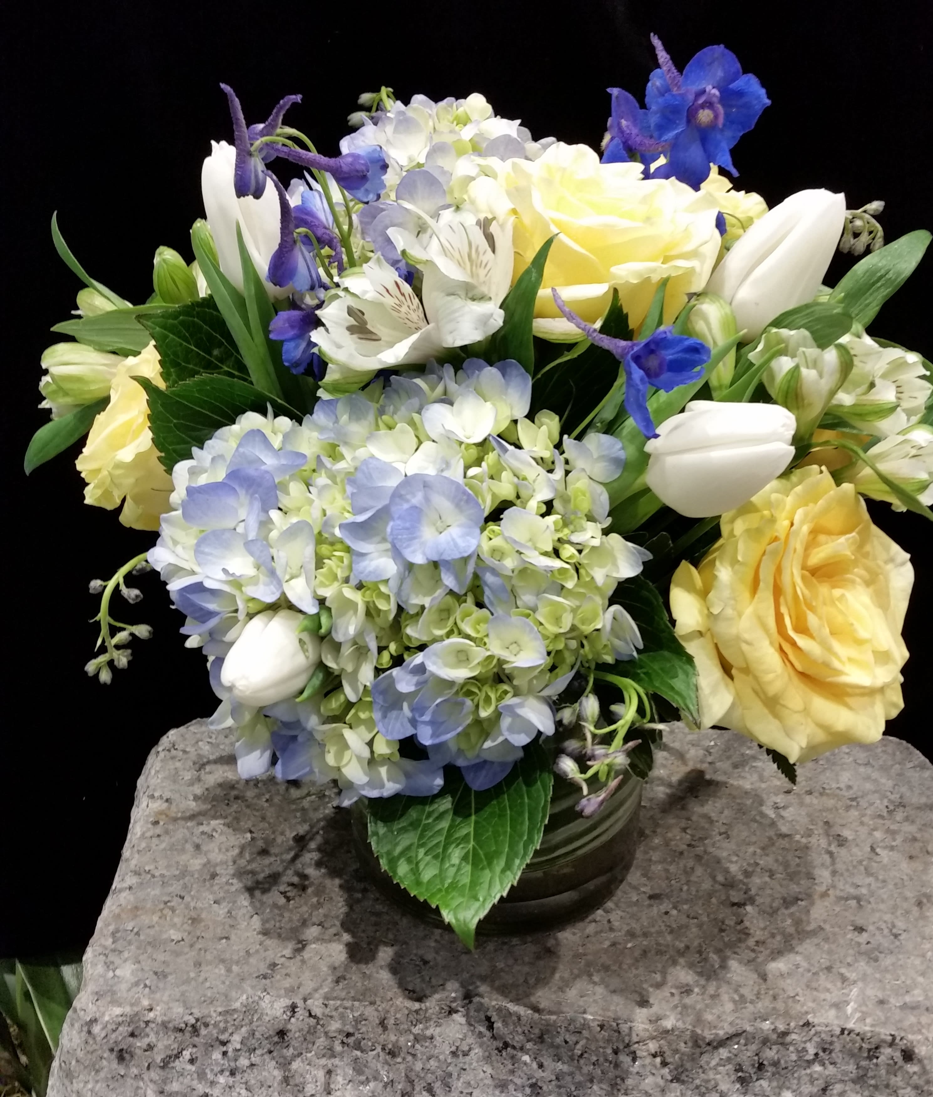 Cottage Blue - A lovely mix of blue hydrangea, yellow roses, white tulips, and royal blue delphinium create the perfect vision of a Cape Cod summer in our Cottage Blue arrangement.  We love the beach and everything that goes with it.  Cape Cod's hydrangeas are a favorite loved by all.  You can have your own blue hydrangea just order this stunner!