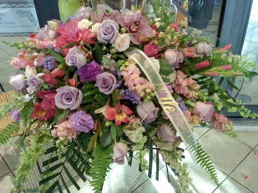 Large pastel floral spray with roses and orchids on a stand