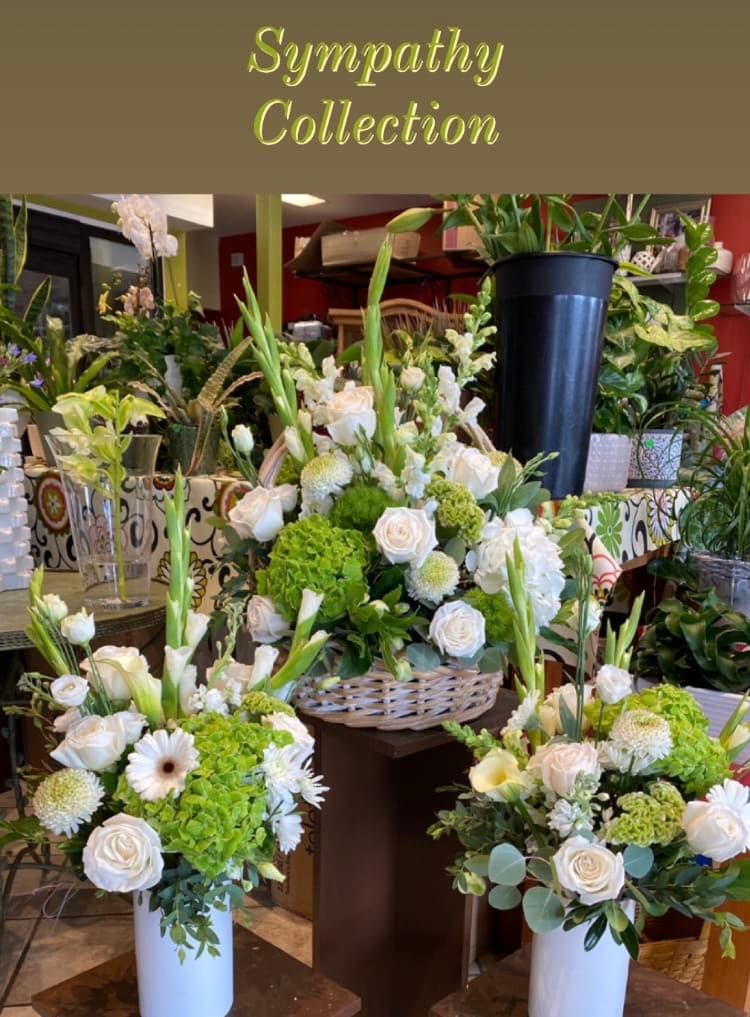 Sympathy floral arrangements with white roses and green blooms in vases and baskets