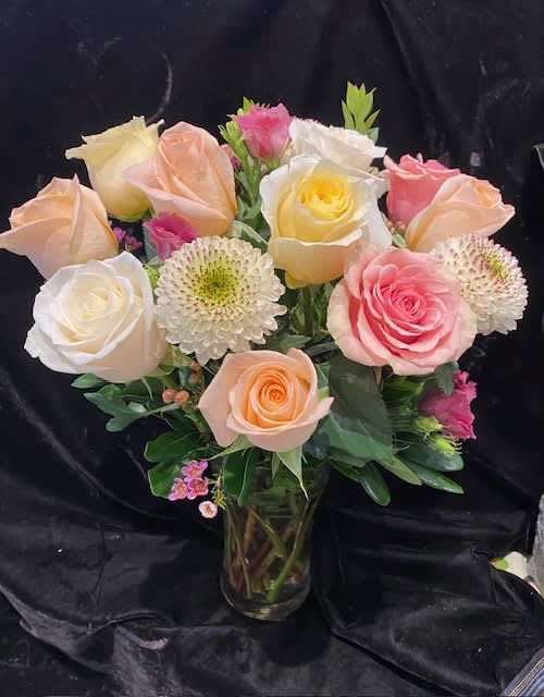 Bouquet of pastel roses and white chrysanthemums in a glass vase
