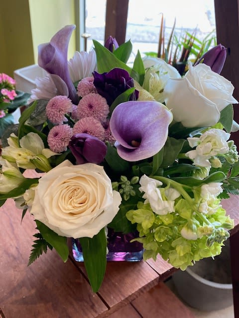 Lavender Mist - Soothing, calm, peaceful, relaxed.......that is what the color lavender symbolizes to me.  This lovely arrangement in a lavender vase is lovely for any occasion; birthday, get well, thank you, anniversary.  The colors are so pretty and the premium flowers will show the person receiving the flowers that you want to send the very best from Crimson Petal!