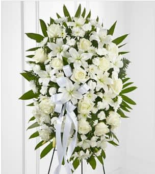 The FTD® Exquisite Tribute™ Standing Spray - The FTD® Exquisite Tribute™ Standing Spray is an elegant display of sweet serenity. White roses, Asiatic lilies, chrysanthemums and mini carnations are artfully arranged amongst emerald palm fronds and lush greens. Accented by white satin ribbon and standing on a wire easel, this standing spray is an outstanding way to honor the life of your loved one. BETTER spray is approximately 33"H x 21"W. Your purchase includes a complimentary personalized gift message.