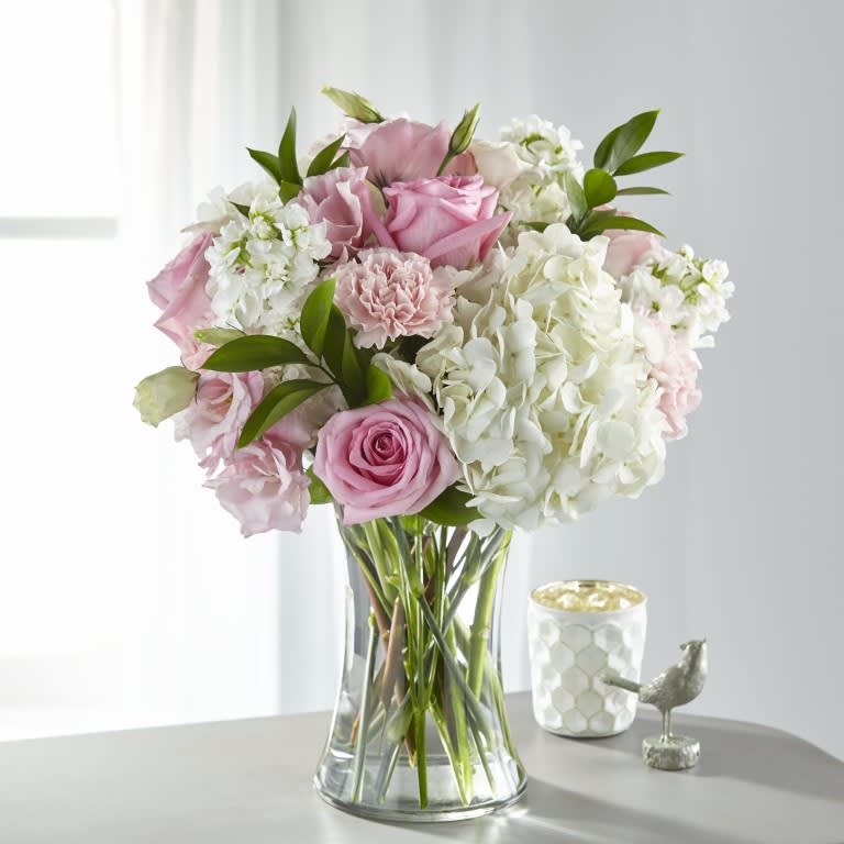 Pink and white bouquet of roses and hydrangeas in a clear glass vase