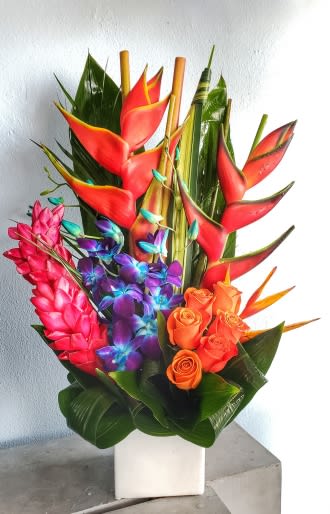 Tropical bouquet with red heliconia, orange roses, and purple orchids in a white vase