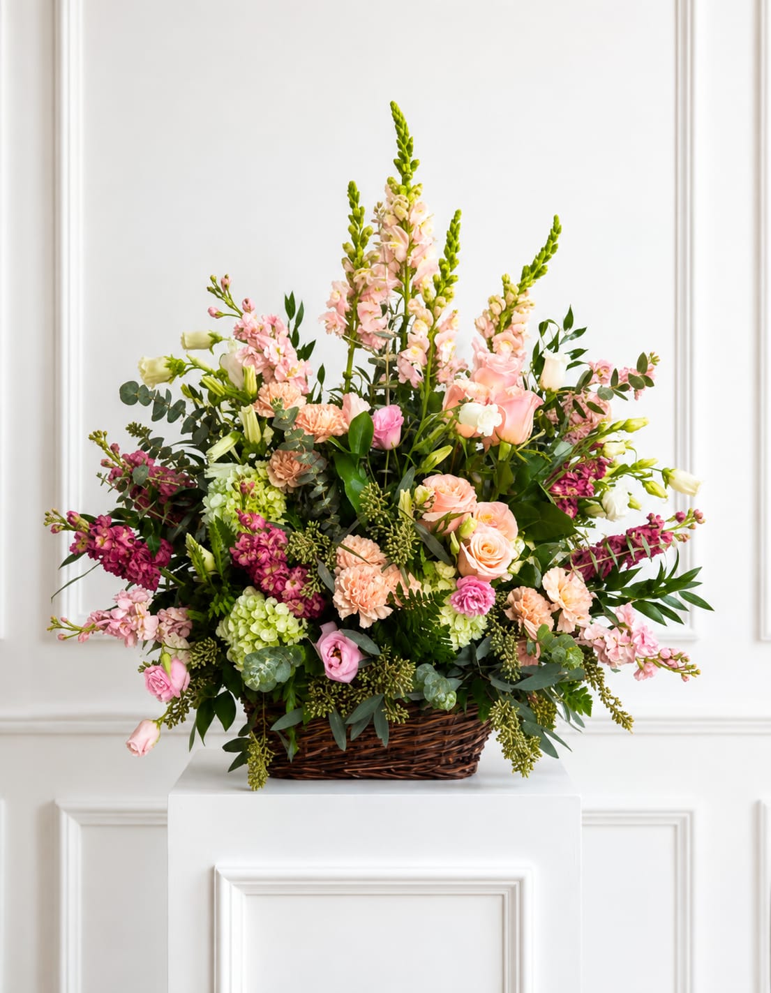 Large pastel flower arrangement in a wicker basket