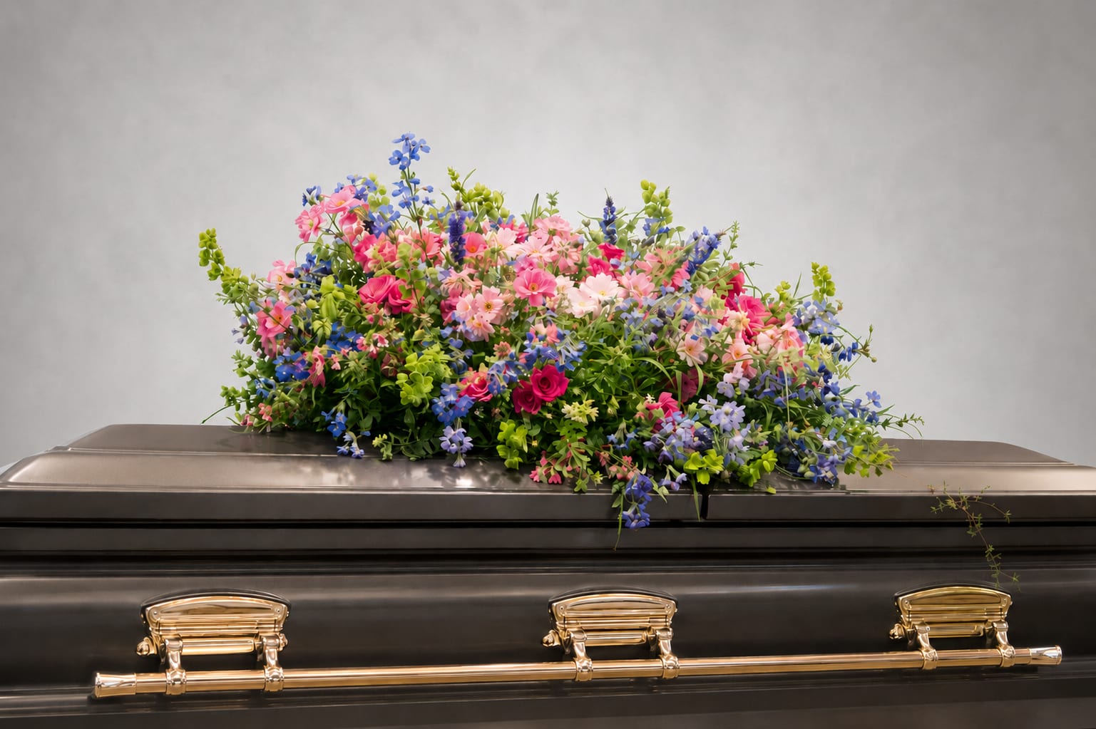 Colorful floral spray arranged on top of a casket