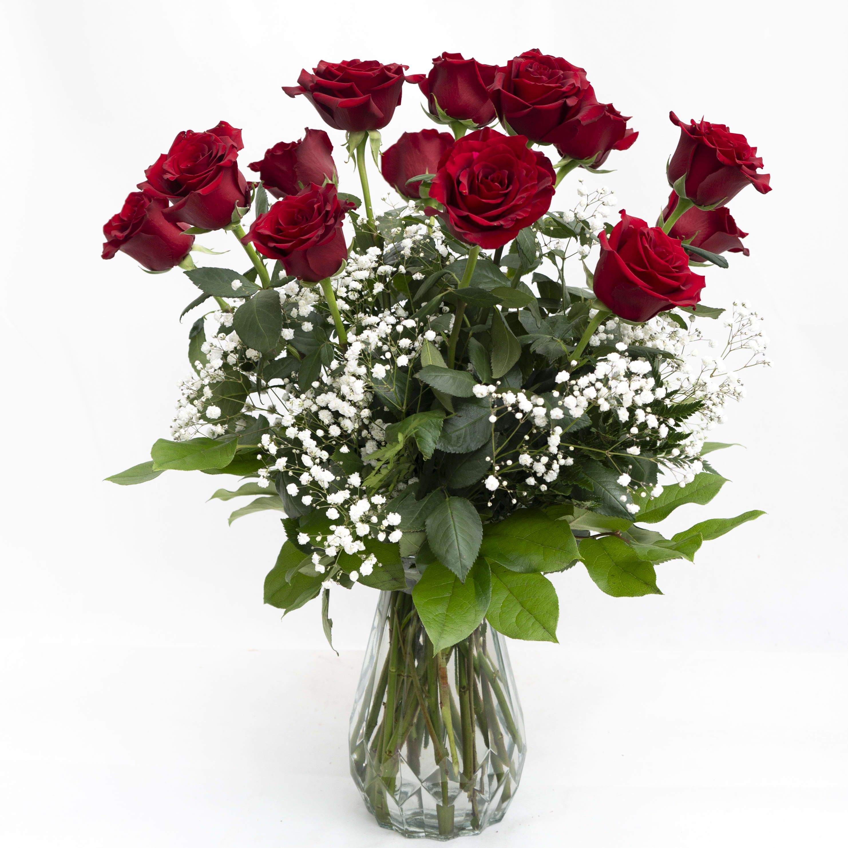 Red roses in a clear glass vase with white baby's breath