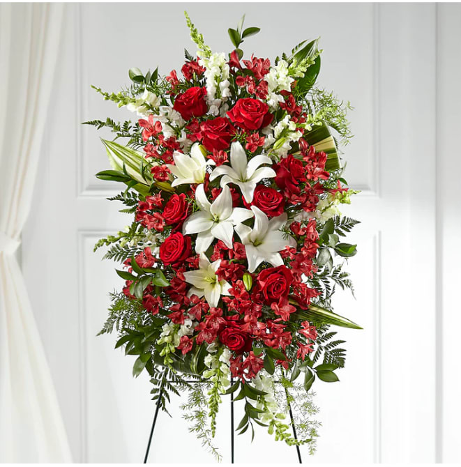 Standing floral spray with red roses, white lilies, and red filler flowers
