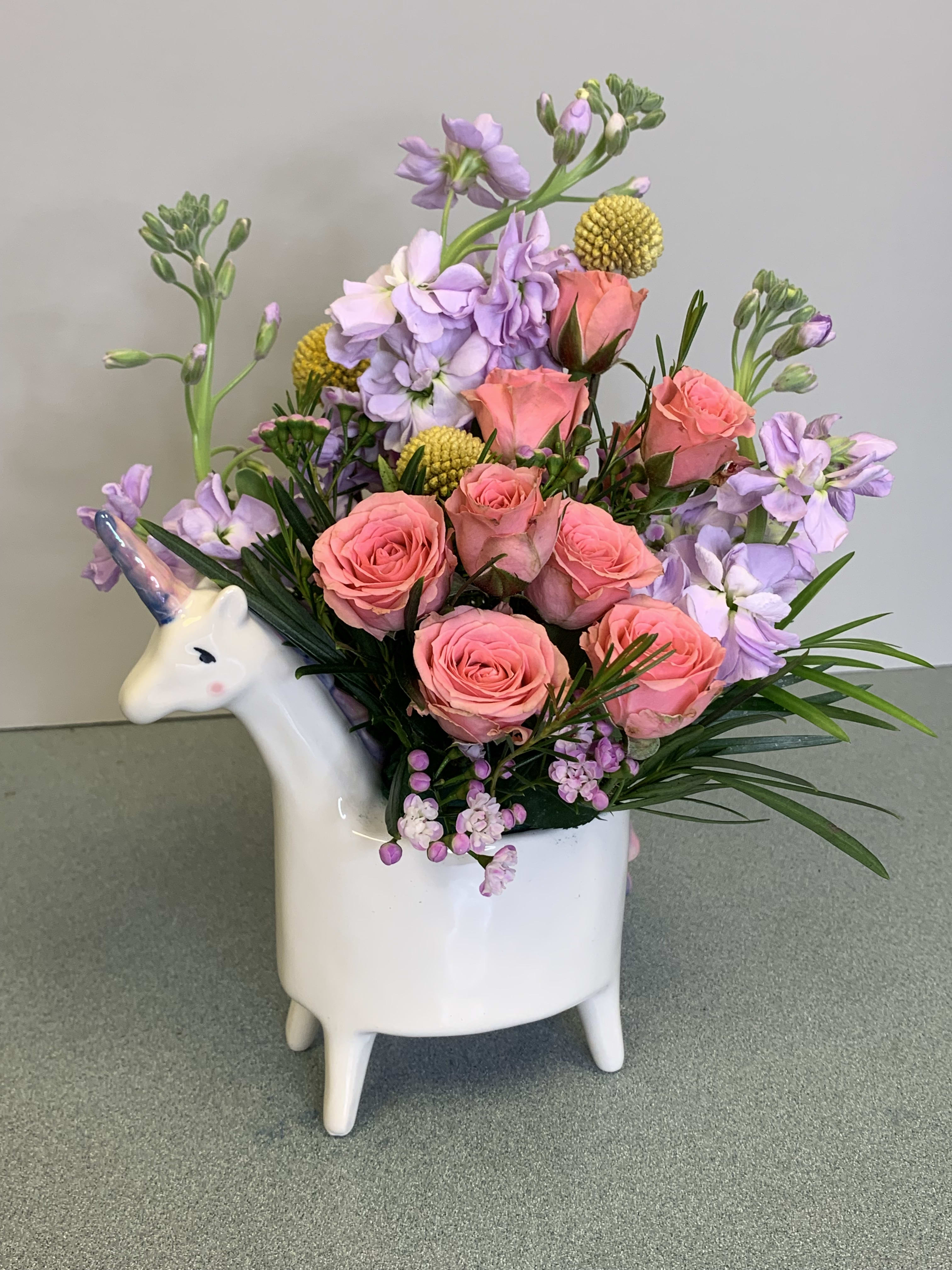 Pink roses and lavender flowers in a unicorn-shaped vase