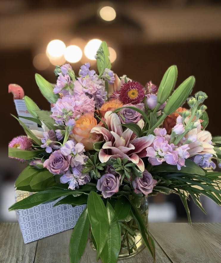 Mixed bouquet of pastel flowers in a glass vase