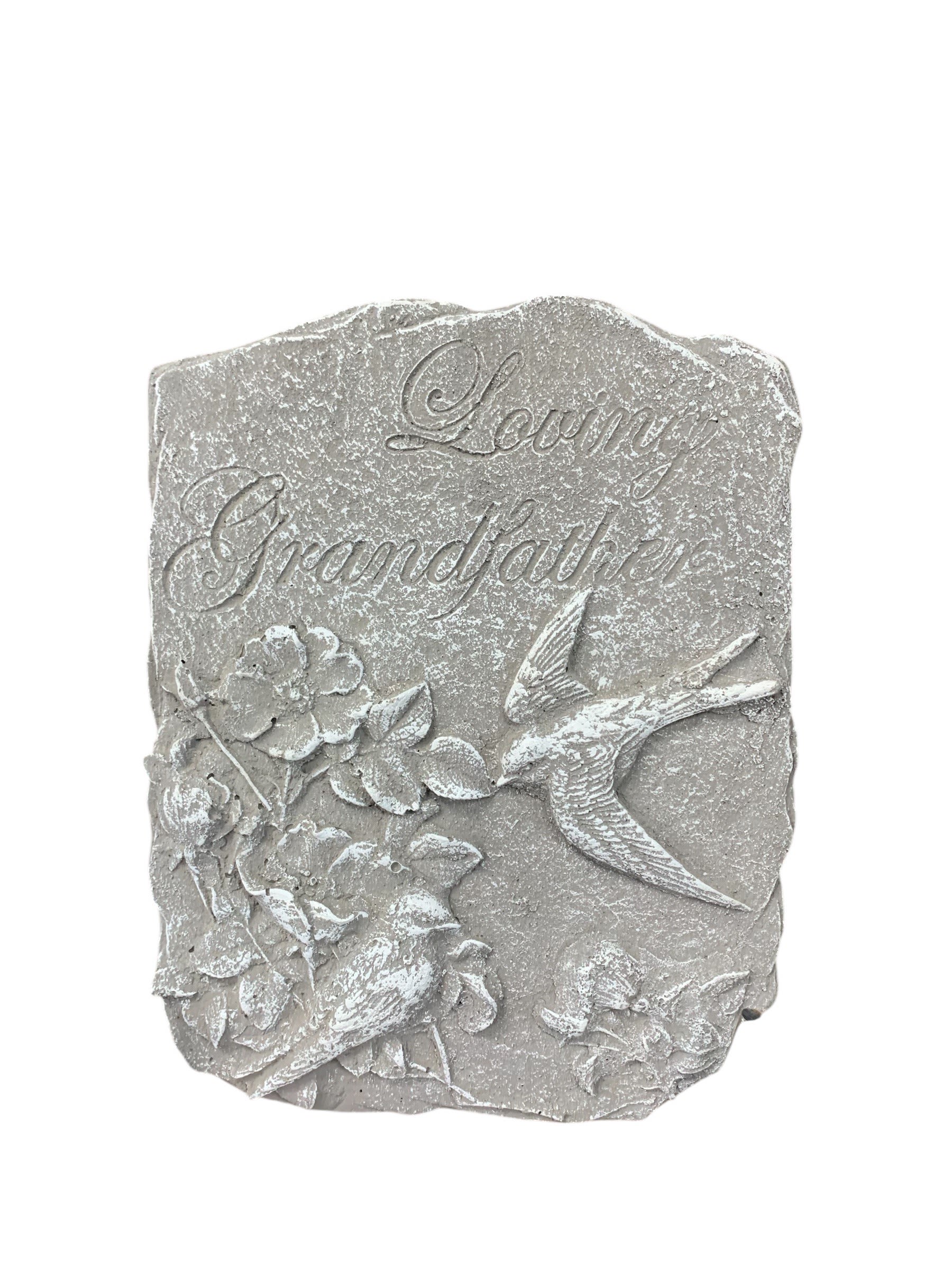Gray memorial plaque with birds and flowers
