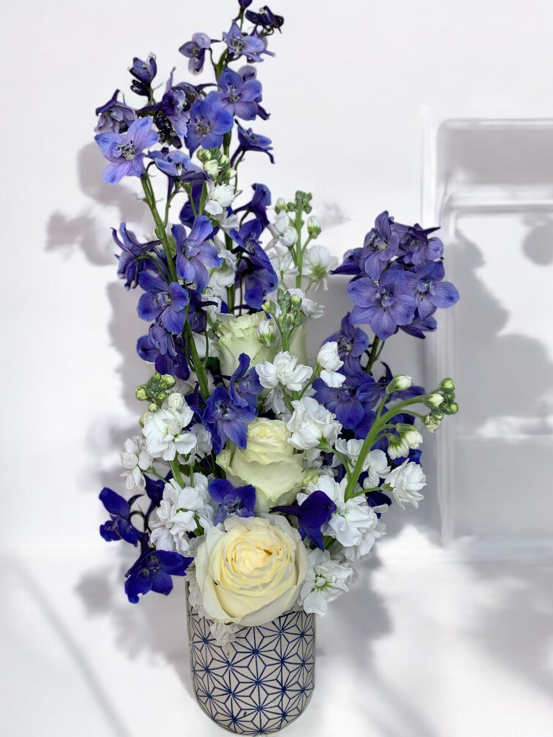 Blue and white floral arrangement in a patterned vase