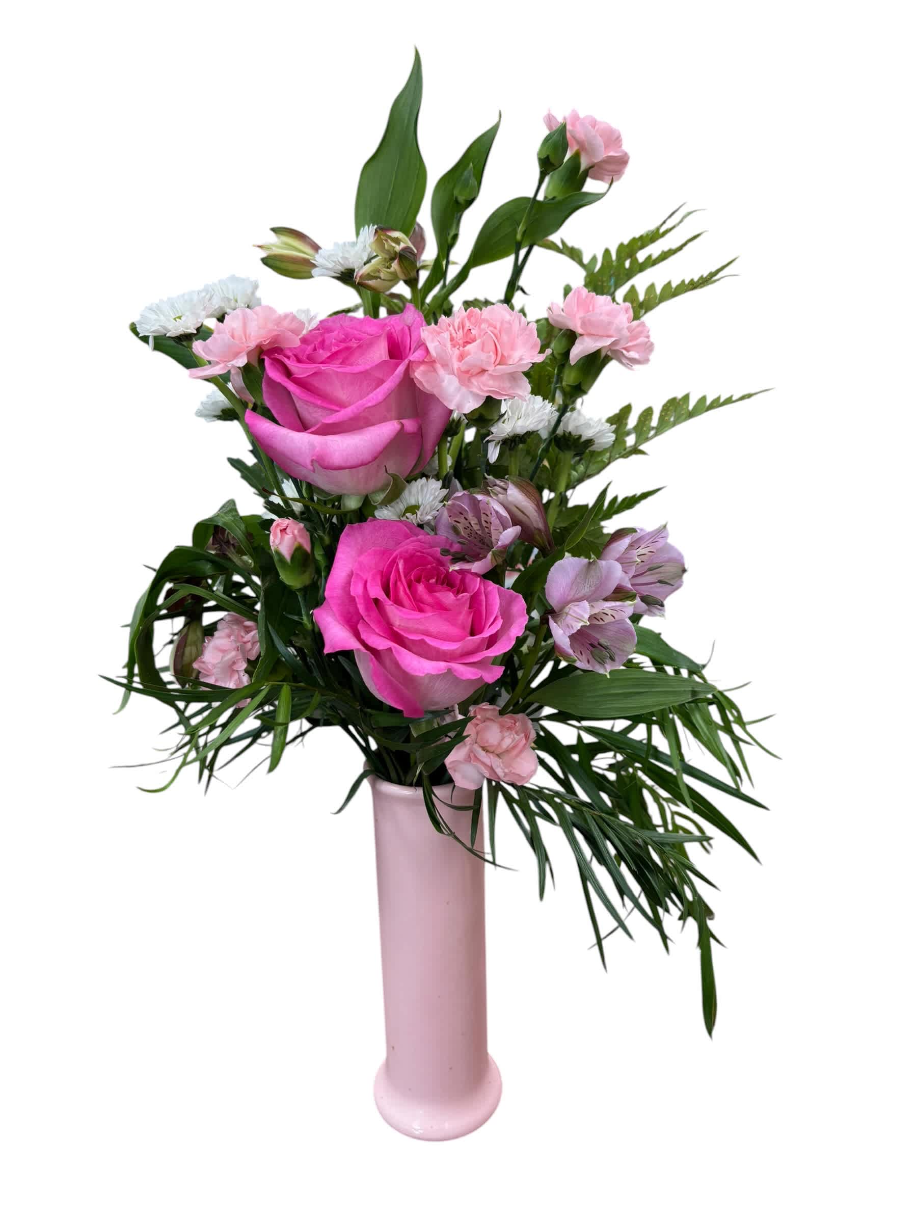 Pink roses and mixed blooms arranged in a tall pink vase