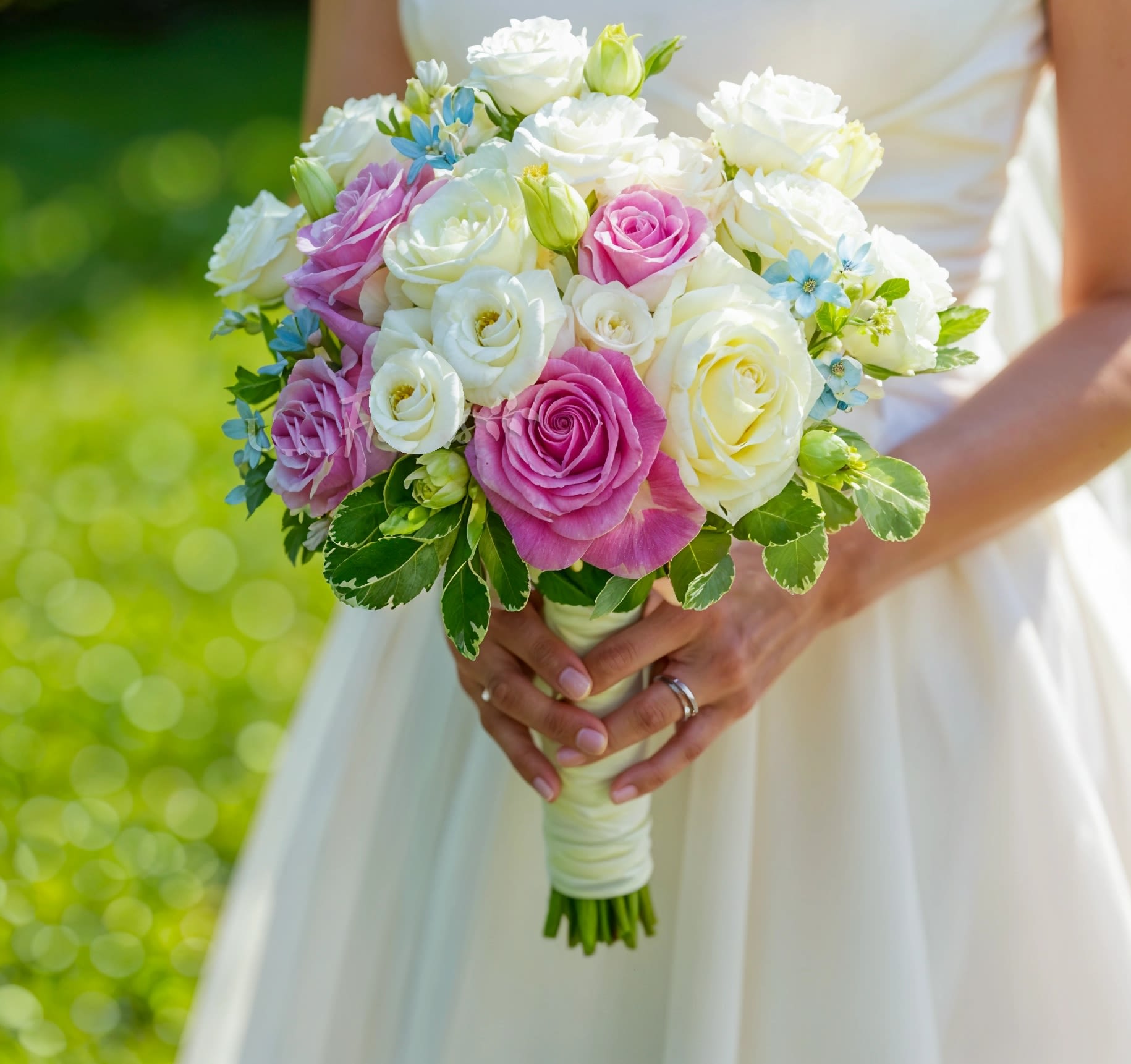  Pink and white bride  Bouquet - This elegant bridal hand-tied bouquet features  soft pink and white roses, delicate white lisianthus, and vibrant blue oxypetalum, all beautifully complemented by fresh green fillers. The soft hues of pink and white, paired with the striking blue accents, create a romantic and refined bouquet, perfect for a bride seeking a blend of elegance, charm, and uniqueness on her wedding day.