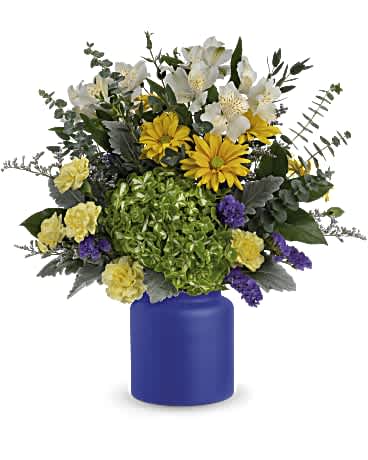 Bouquet of white, yellow, and purple flowers in a blue vase
