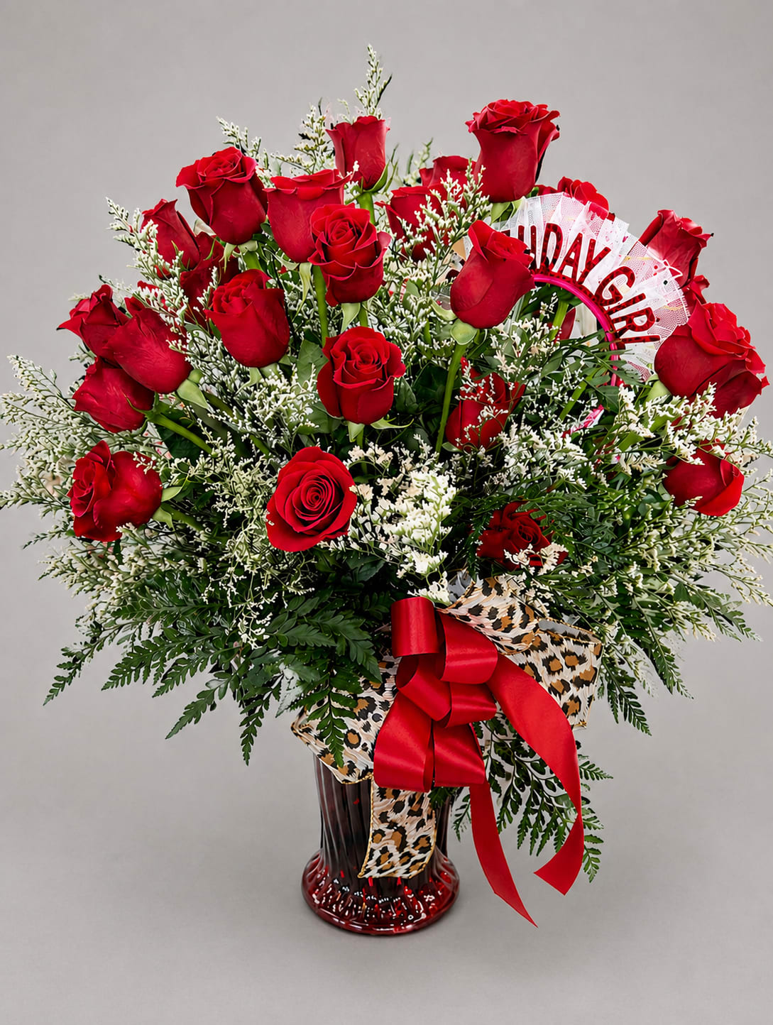 Bouquet of red roses in a glass vase with a red ribbon