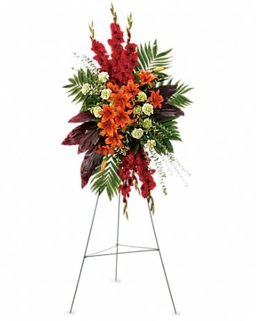 Tall floral standing spray with red and orange flowers on an easel