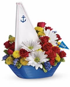 Boat-shaped floral arrangement with red, white, and yellow flowers and a small sail