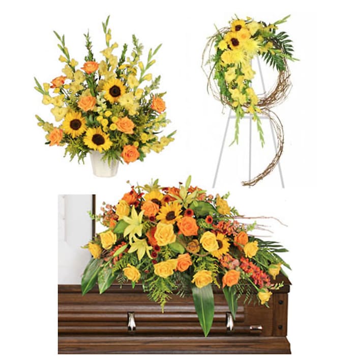 Yellow and orange floral funeral pieces arranged around a casket