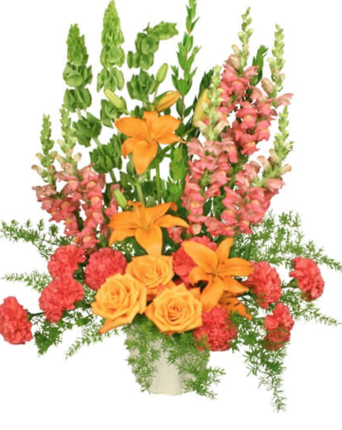 Orange lilies and roses with pink snapdragons in a vase