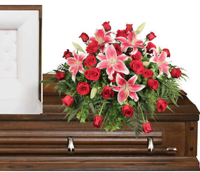 Red roses and pink lilies arranged on a casket