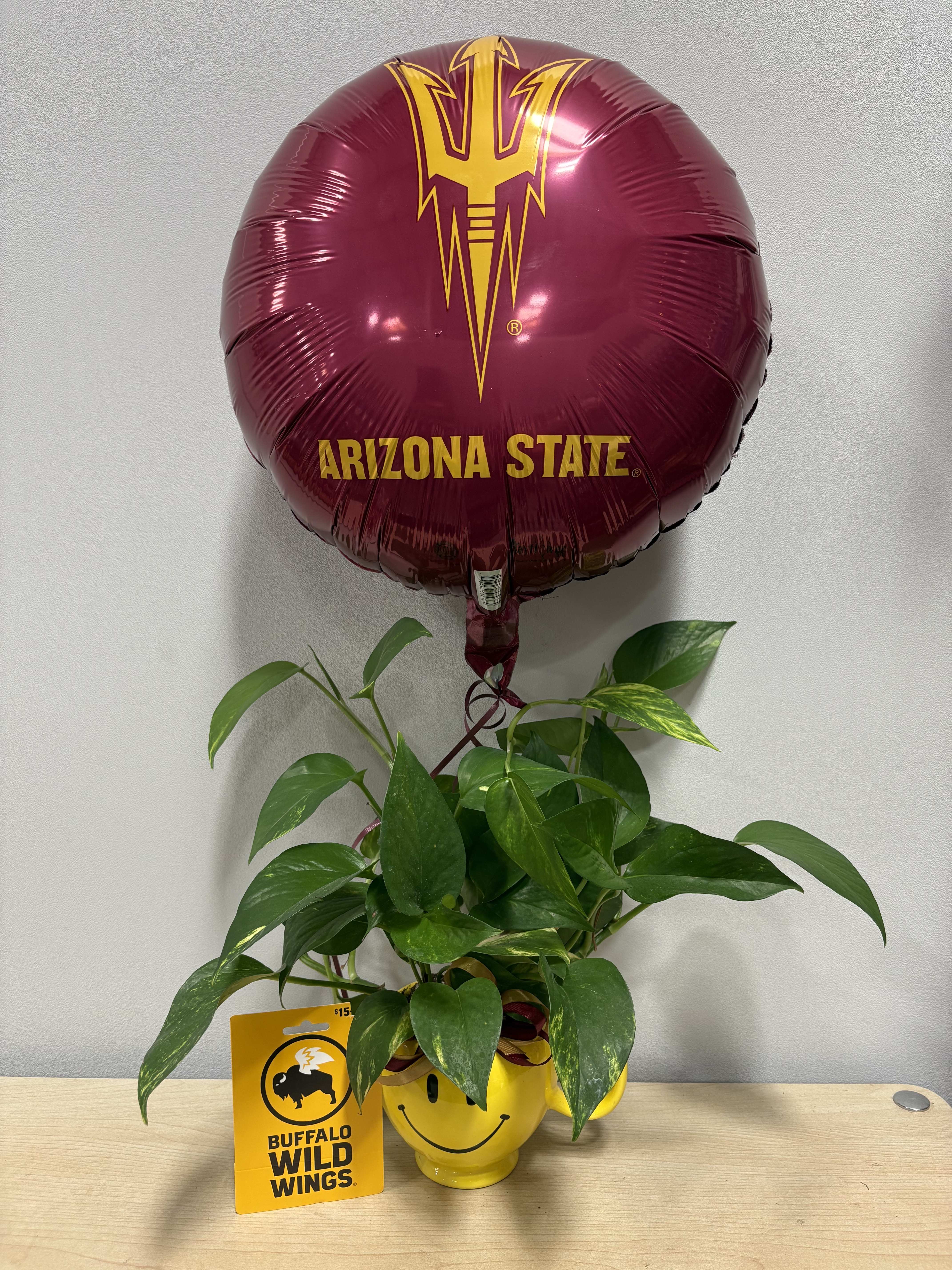 Potted green plant with a maroon Arizona State balloon and a Buffalo Wild Wings card
