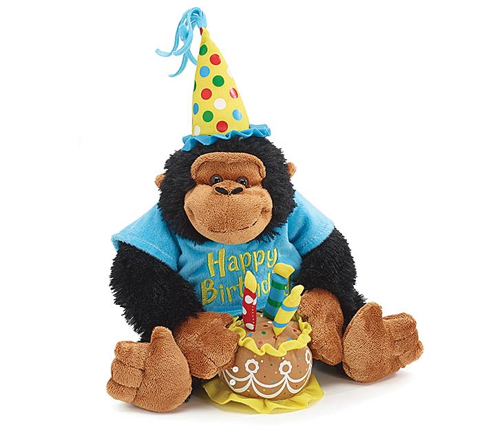 PLUSH MUSICAL Happy Birthday GORILLA - A black-and-brown monkey is wearing a blue T-shirt with "Happy Birthday" embroidered on it. The monkey is holding a cake with three candles on top. A musical chip in the cake plays a soft Happy Birthday Song.  12"high from head to toe.