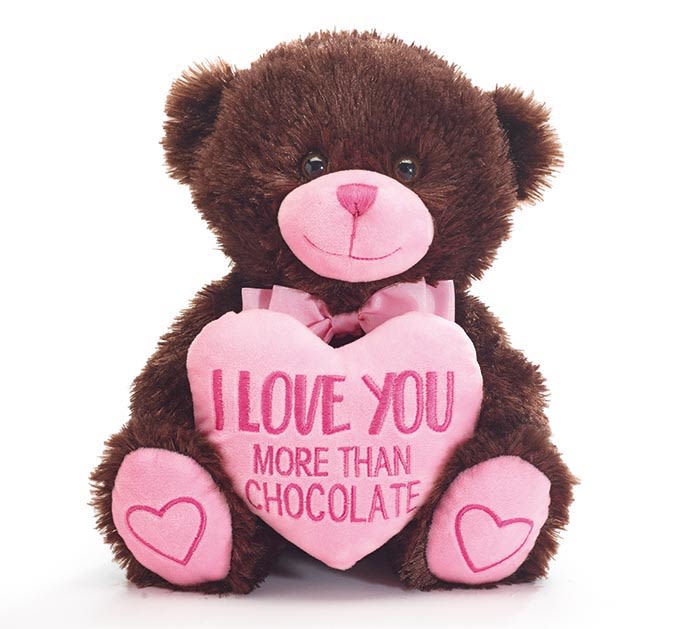 Brown teddy bear holding a pink heart with text