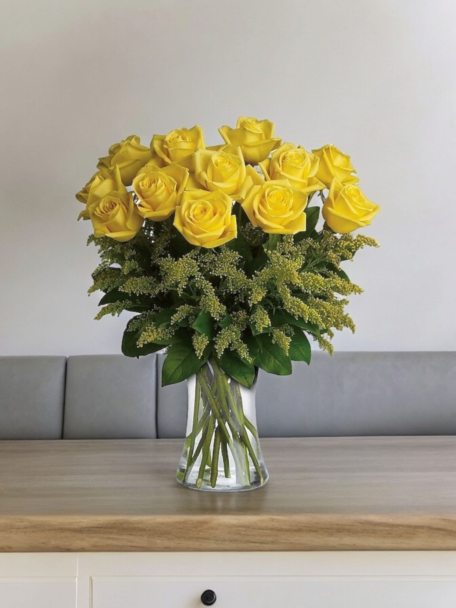Yellow roses arranged in a clear glass vase