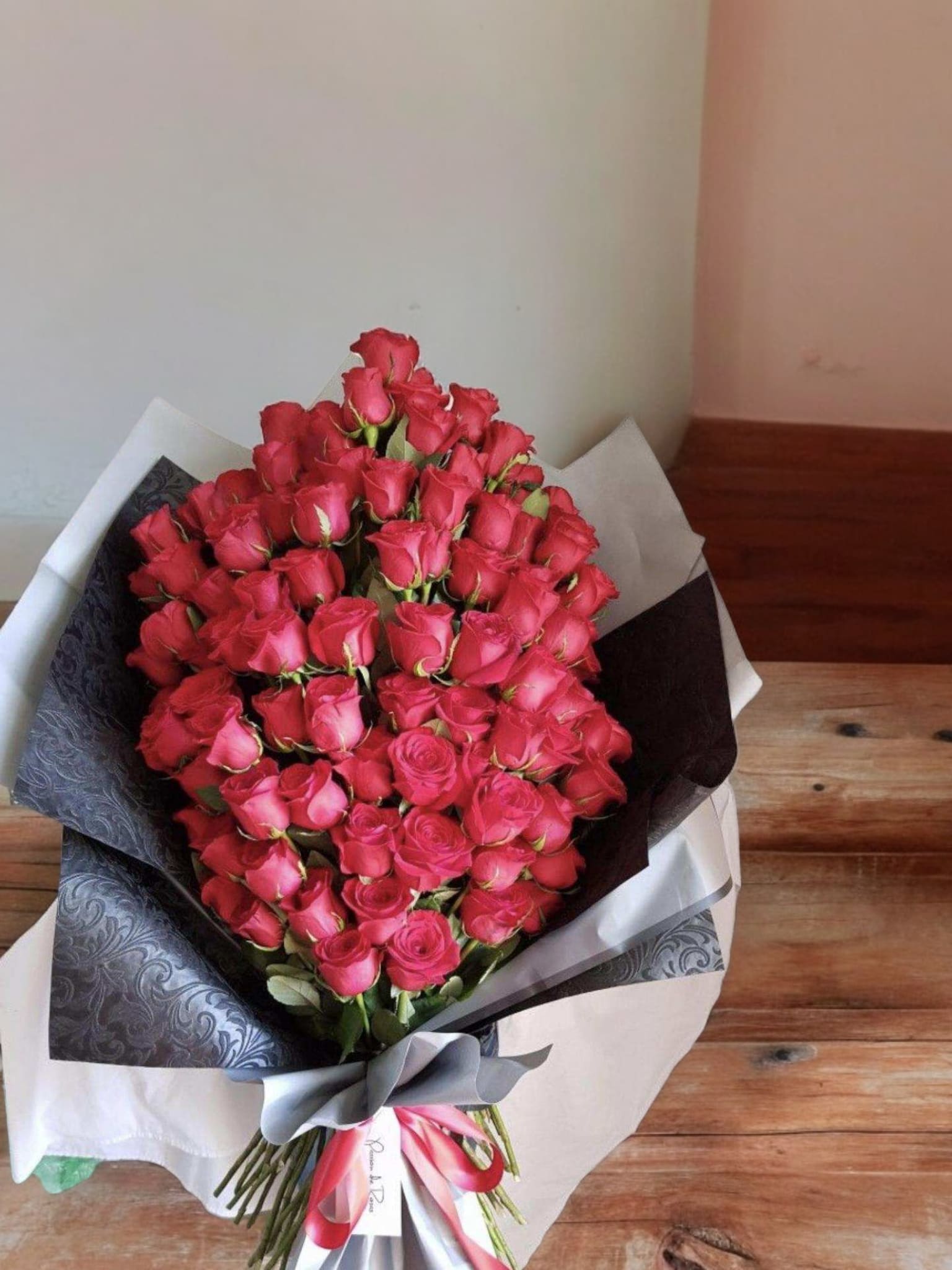 Large bouquet of pink roses wrapped in black and white paper