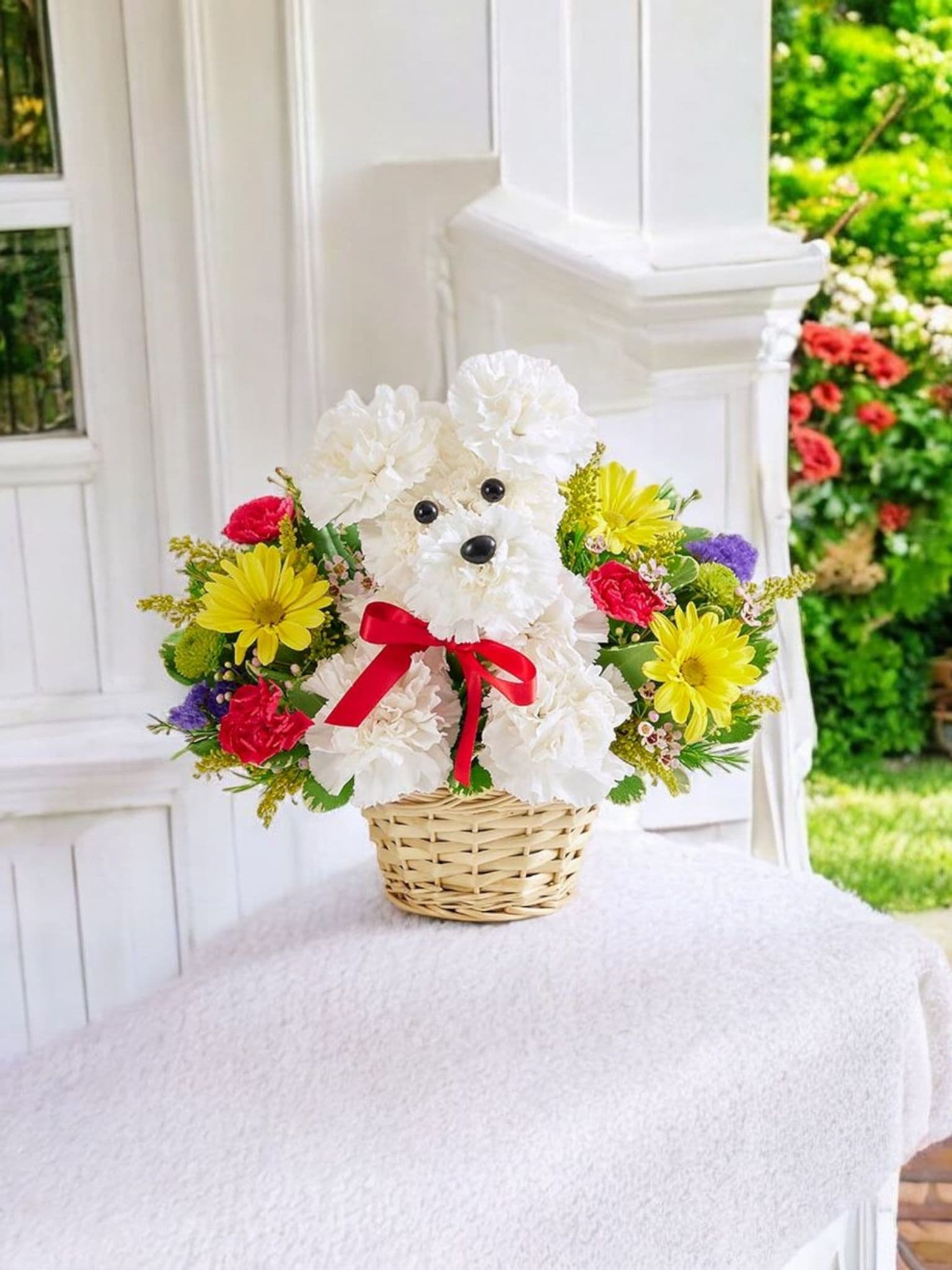 Flower basket arranged as a white teddy bear with a red bow