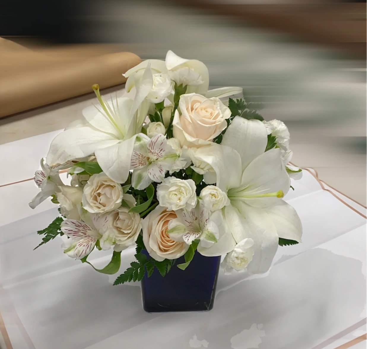 White floral arrangement in a dark square vase
