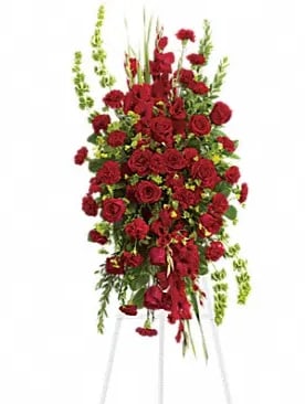 Tall standing arrangement of red roses and greenery on a white easel