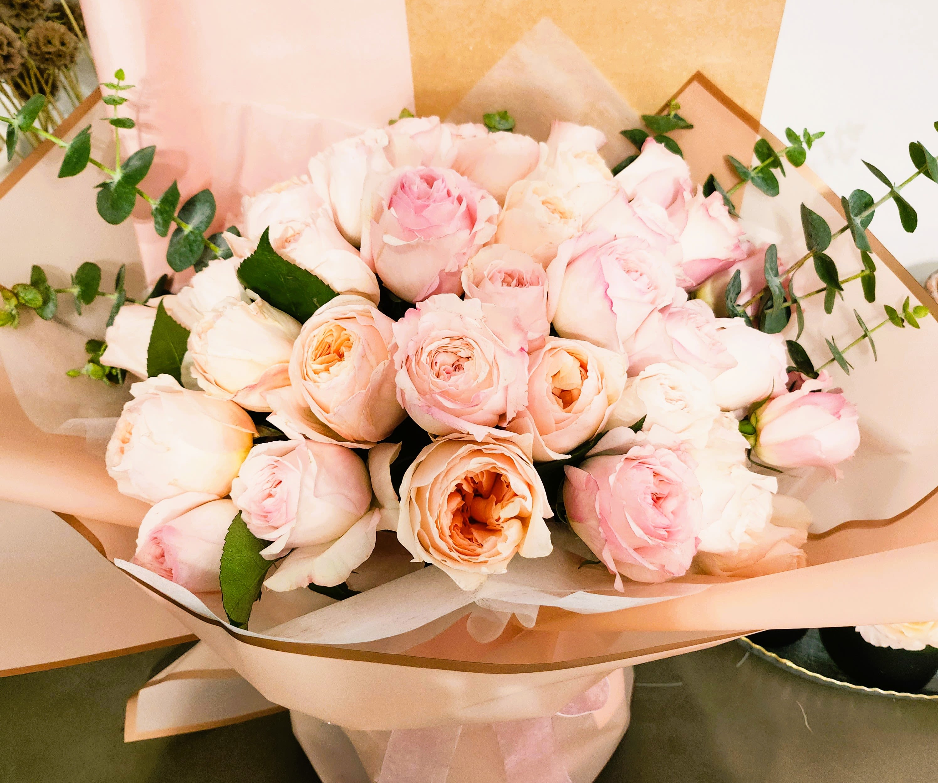 Bouquet of pale pink roses wrapped in blush paper