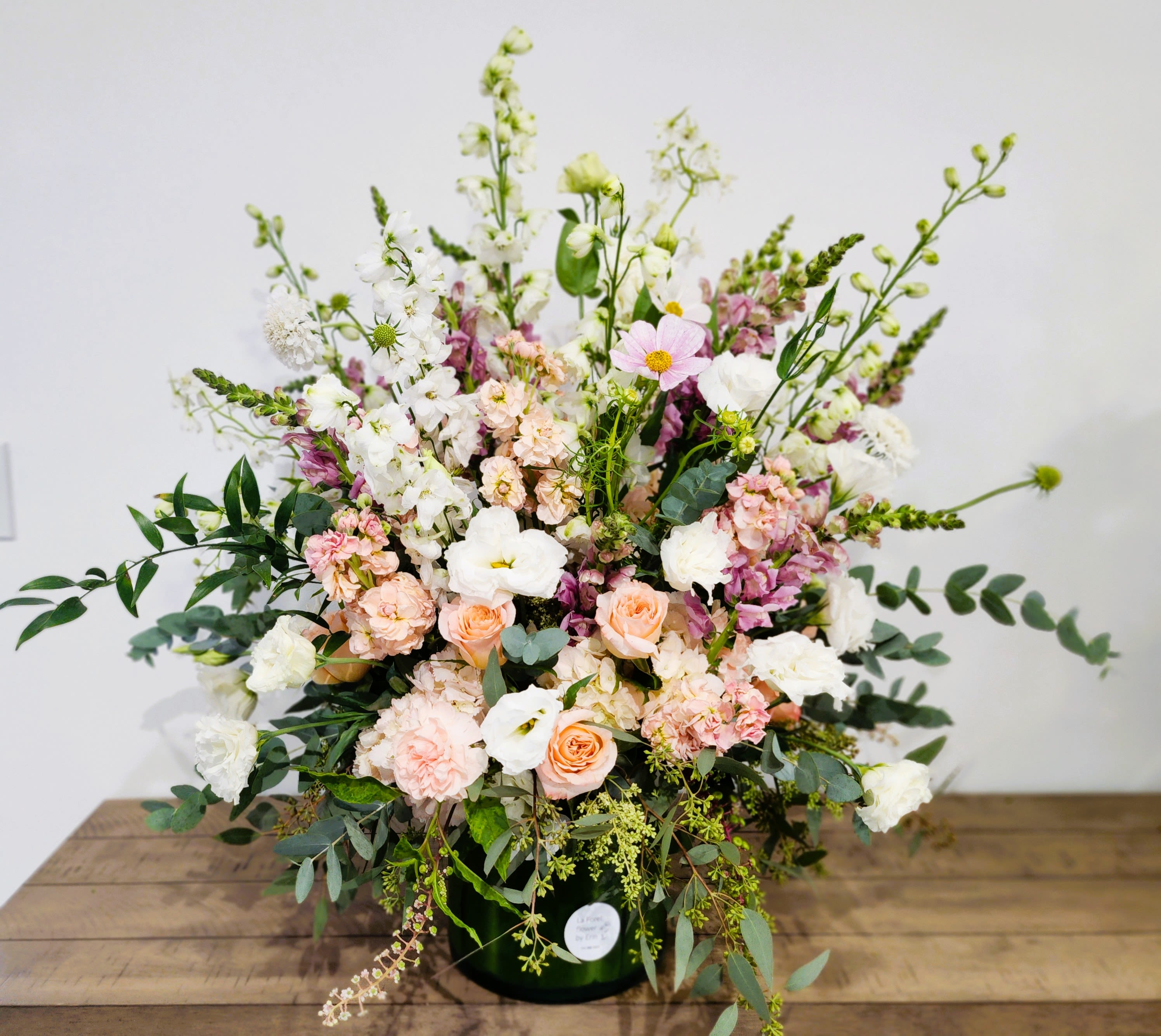 Large pastel floral arrangement in a dark vase