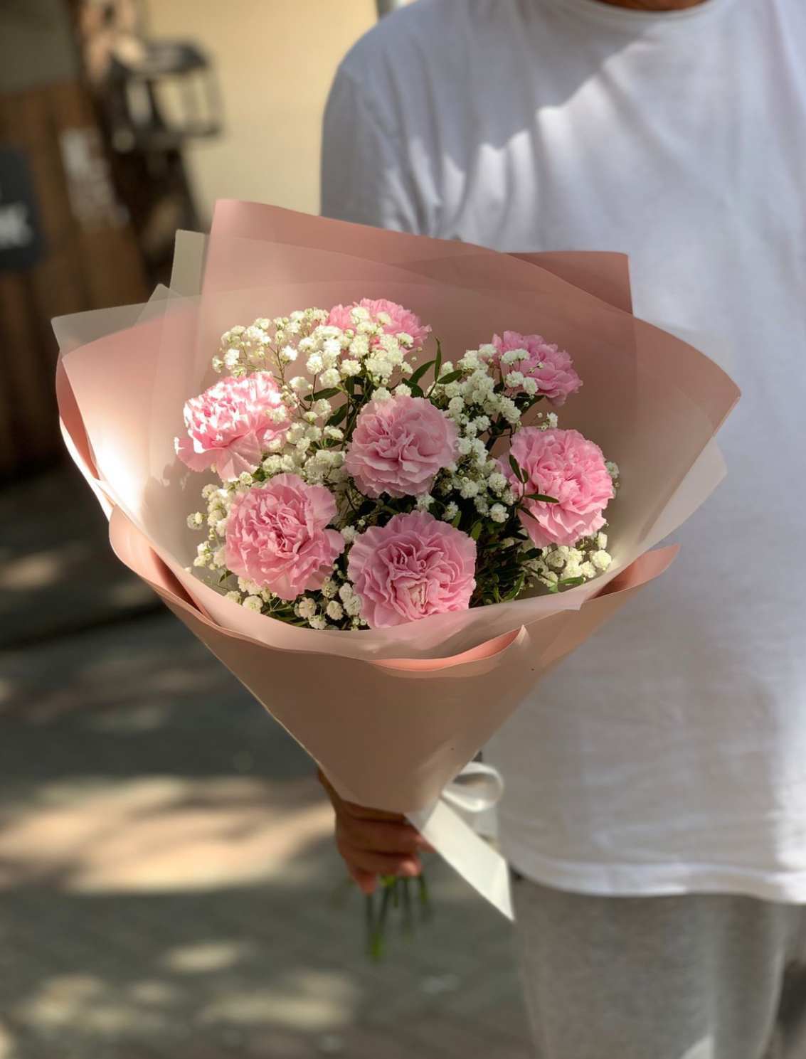 Pink carnation bouquet wrapped in blush paper
