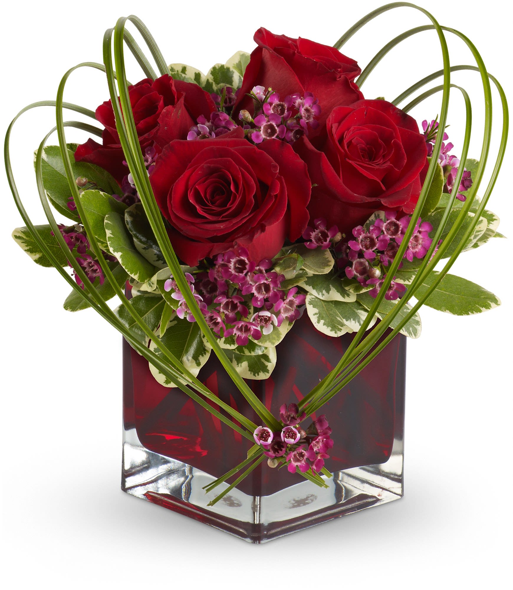 Red roses and purple filler flowers in a square glass vase