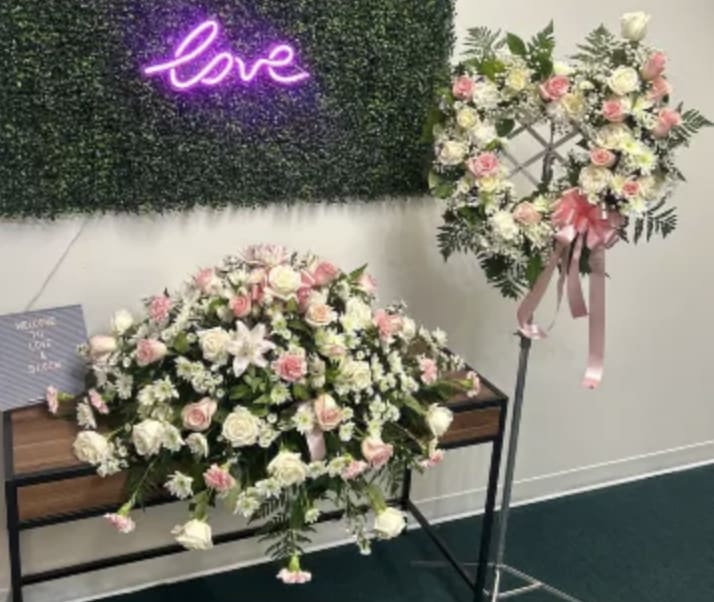 Pink and white floral arrangements with a neon love sign