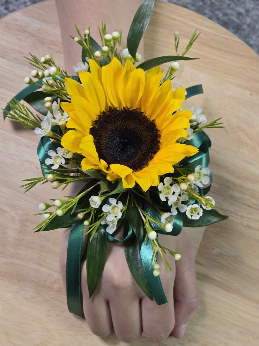 Sunflower wrist corsage with white filler flowers and teal ribbon