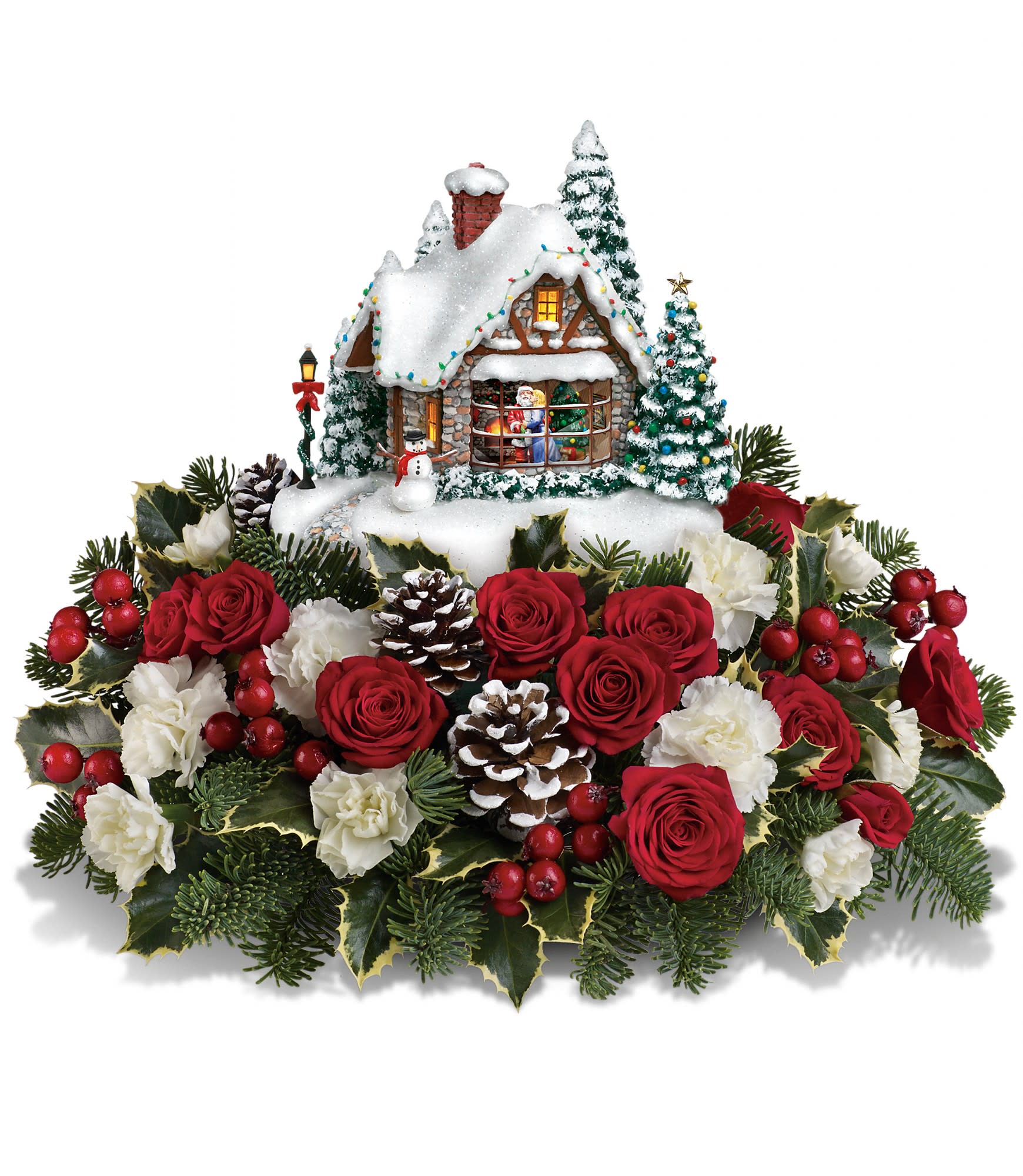 Christmas centerpiece with red roses, white carnations, and a snowy cottage decoration