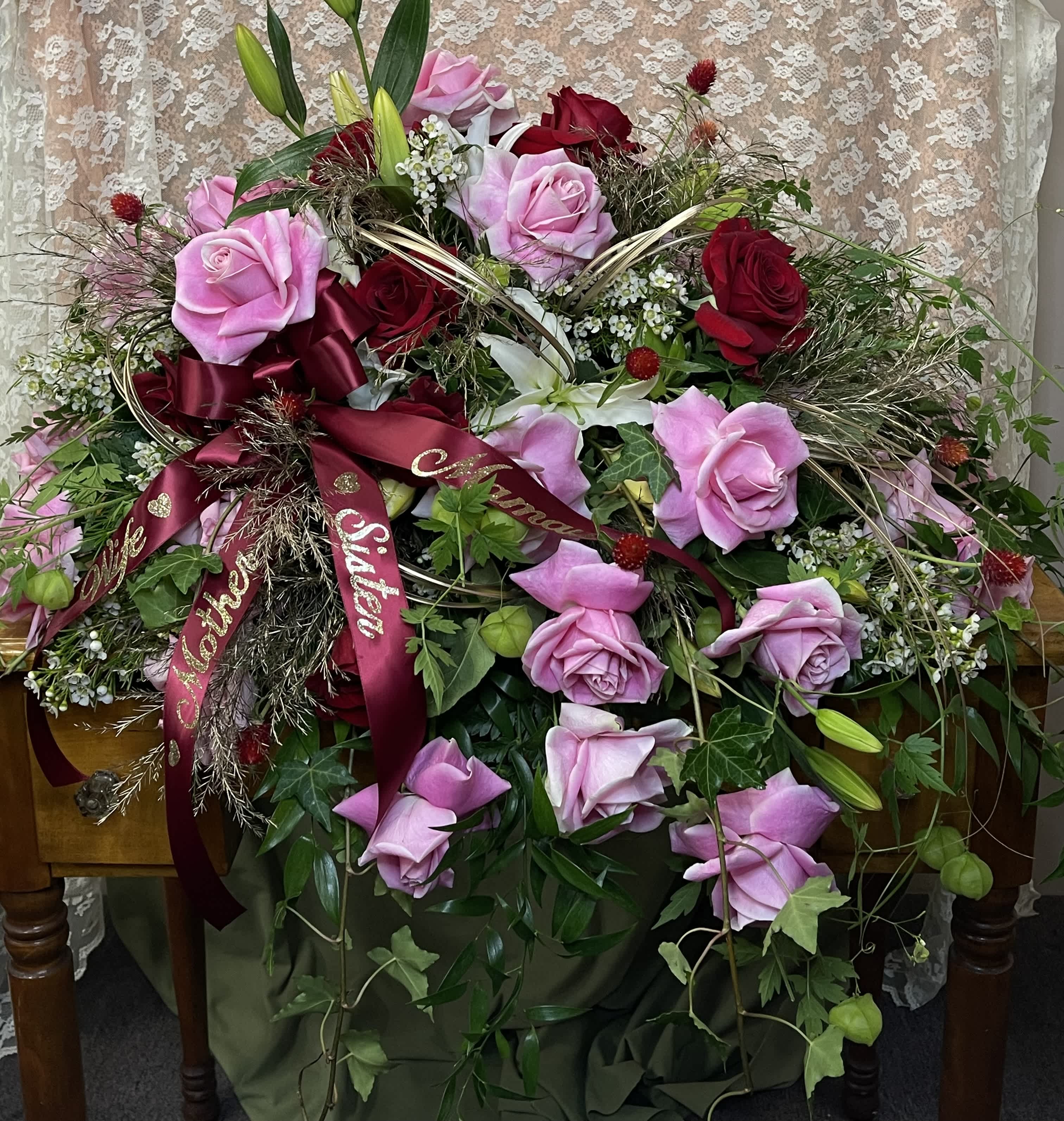 Large bouquet of pink and red roses with ribbon on a table