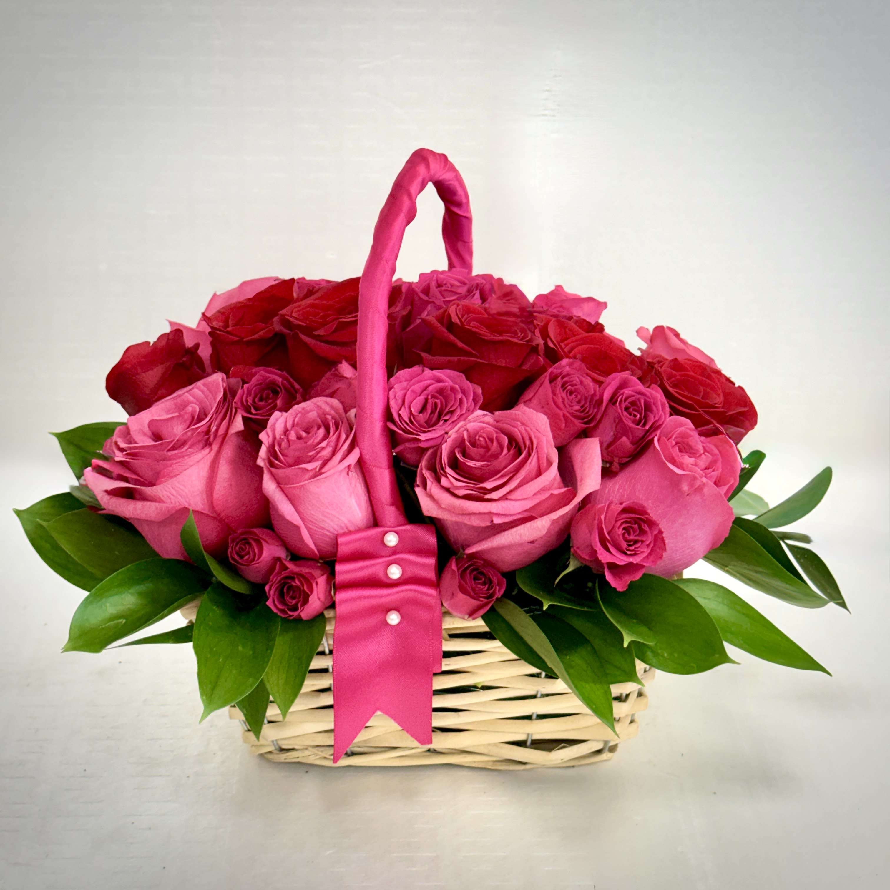 Blushing Rose Basket - A beautiful collection of fresh pink and red roses accented with greenery, designed to brighten any room and any occasion.