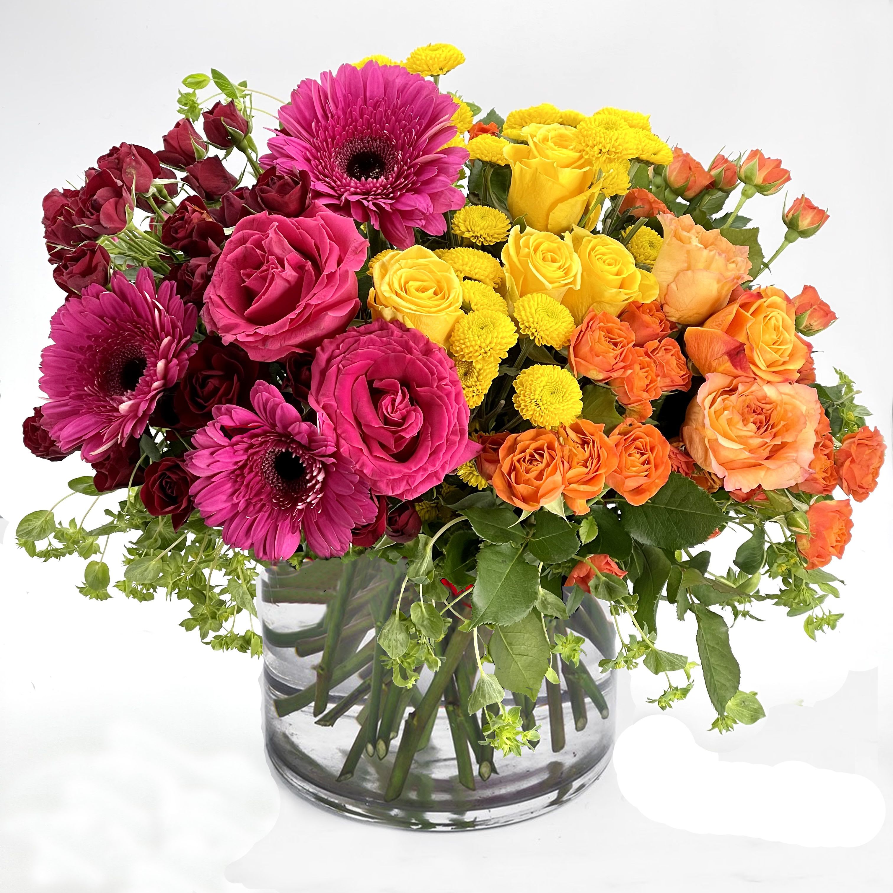 Color Burst Bouquet - Put a spring in their step with this Color Burst Bouquet of hot pink, Yellow, Orange Roses, Hot Pink Gerberas, orange, yellow, red Spray roses, with assorted greeneries. A perfect treat for any occasion!