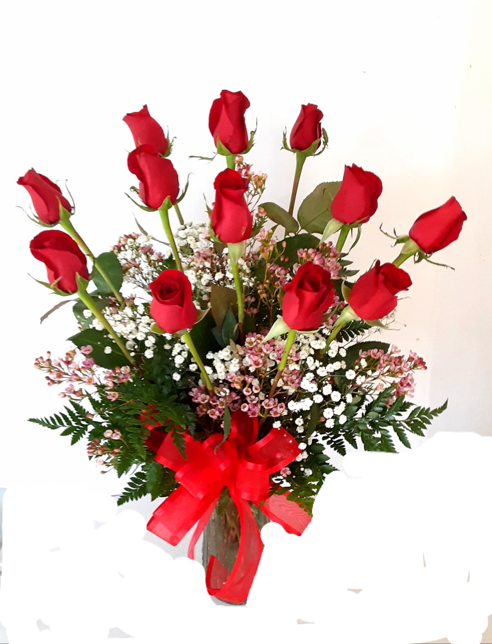 Bouquet of red roses with baby's breath in a glass vase