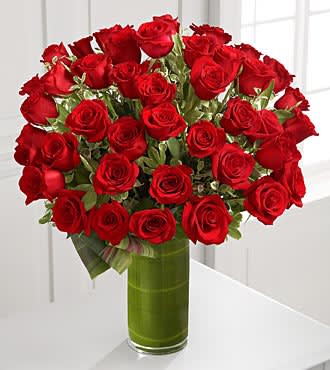 Bouquet of red roses in a tall glass vase