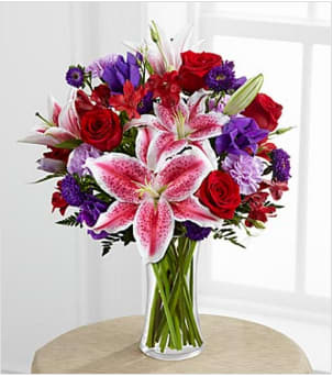 Stunning Beauty  - Stunning Beauty Bouquet by is an absolutely lovely way to send your love and affection across the miles. Fragrant Stargazer lilies stretch their star-like petals across a bed of rich red roses, lavender carnations, red Peruvian lilies, purple double lisianthus, purple matsumoto asters and lush greens. Presented in a classic clear glass vase, this elegant bouquet is an incredible way to convey your sweetest sentiments.  BETTER bouquet is approximately 19"H x 16"W.  Lilies may arrive in various stages of development. The lily blooms will continue to open, extending arrangement life - and your recipient's enjoyment.. Your purchase includes a complimentary personalized gift message.