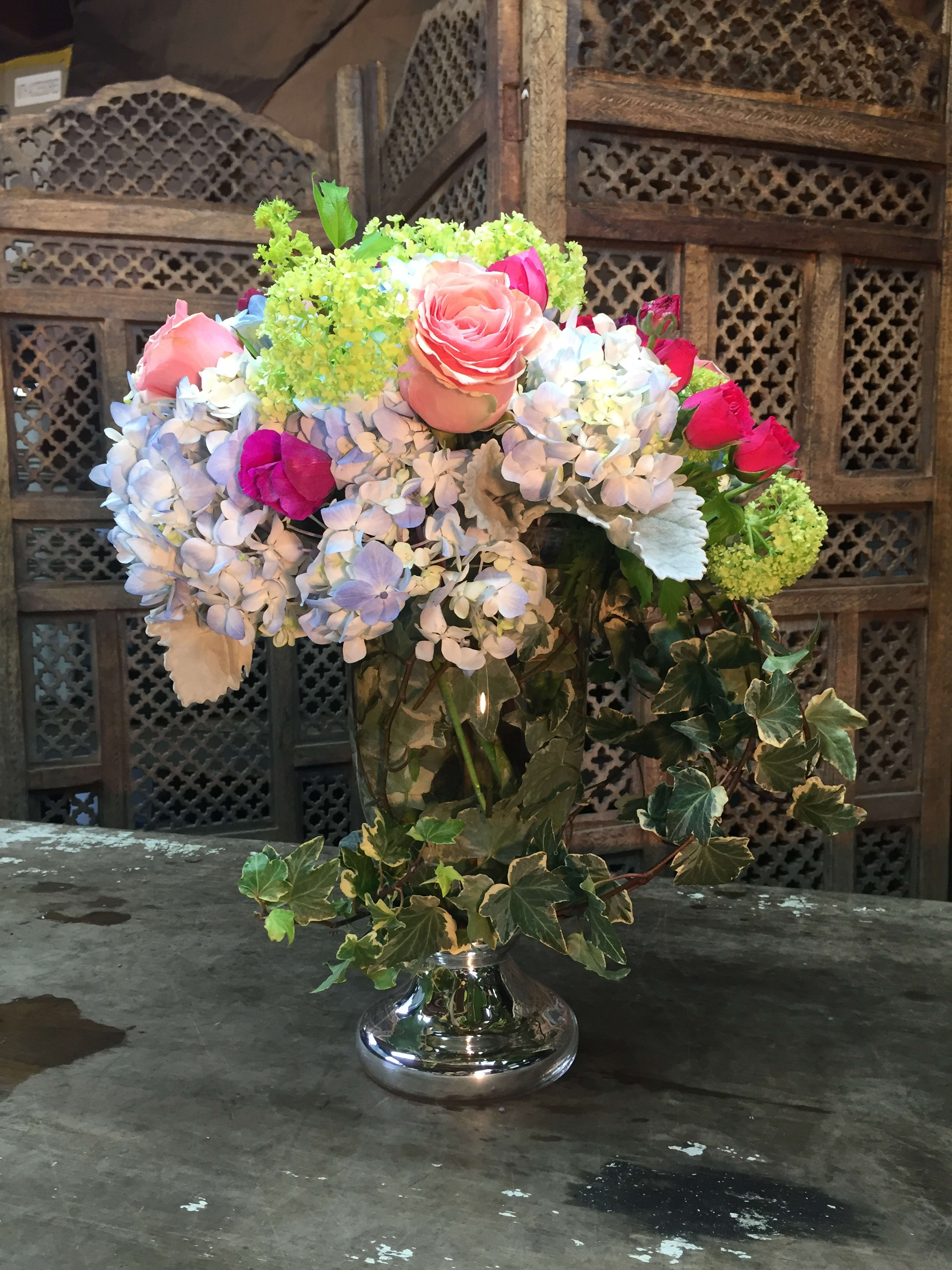 Mixed bouquet of roses and hydrangeas in a silver vase