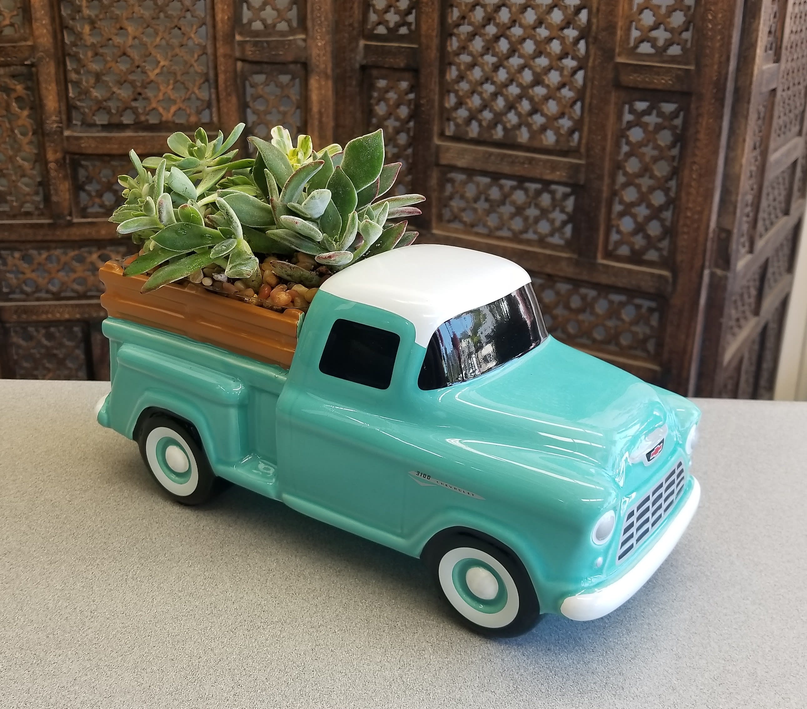 Succulents arranged in a turquoise ceramic truck planter