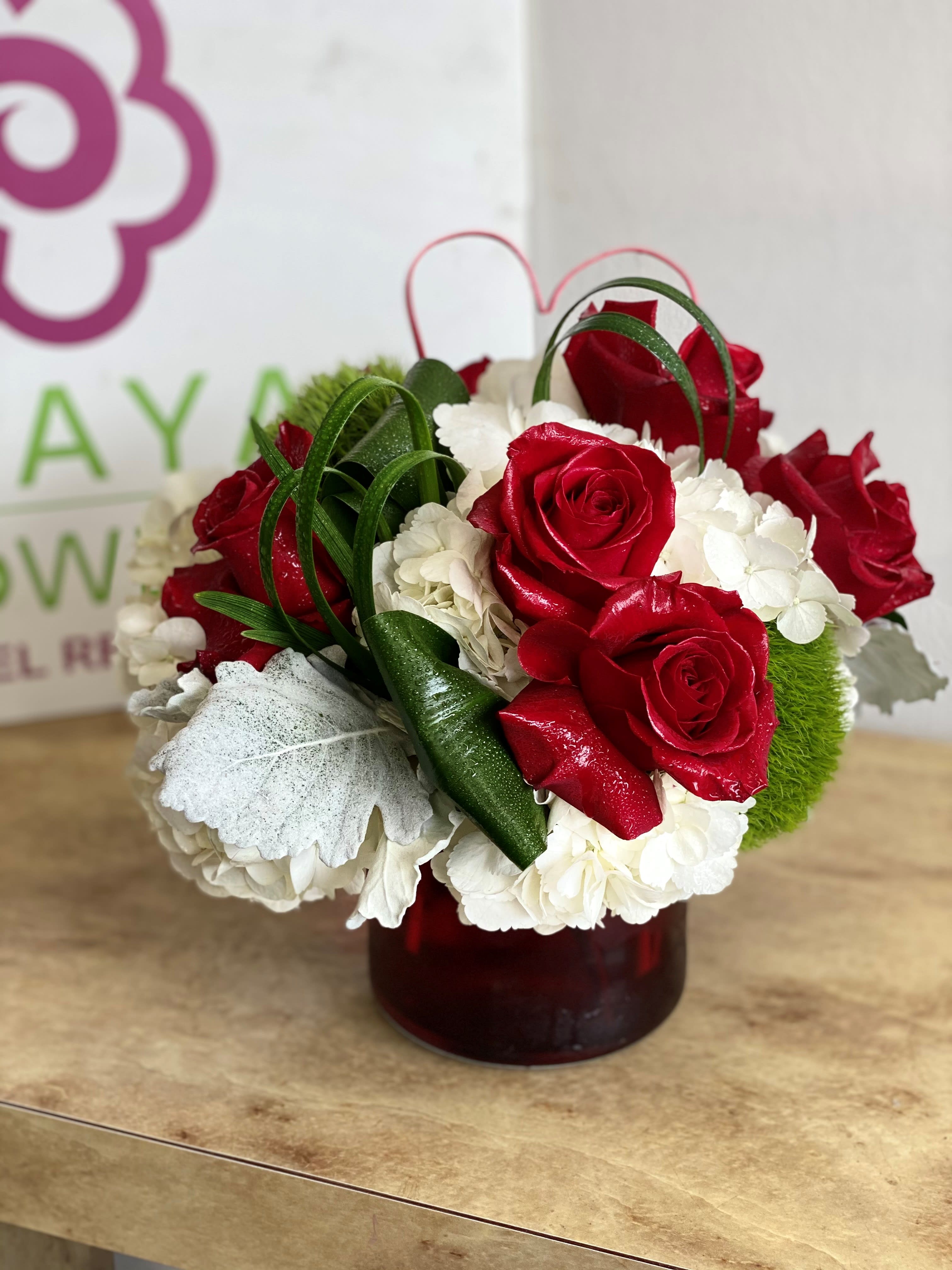 Red roses and white hydrangeas arranged in a red vase