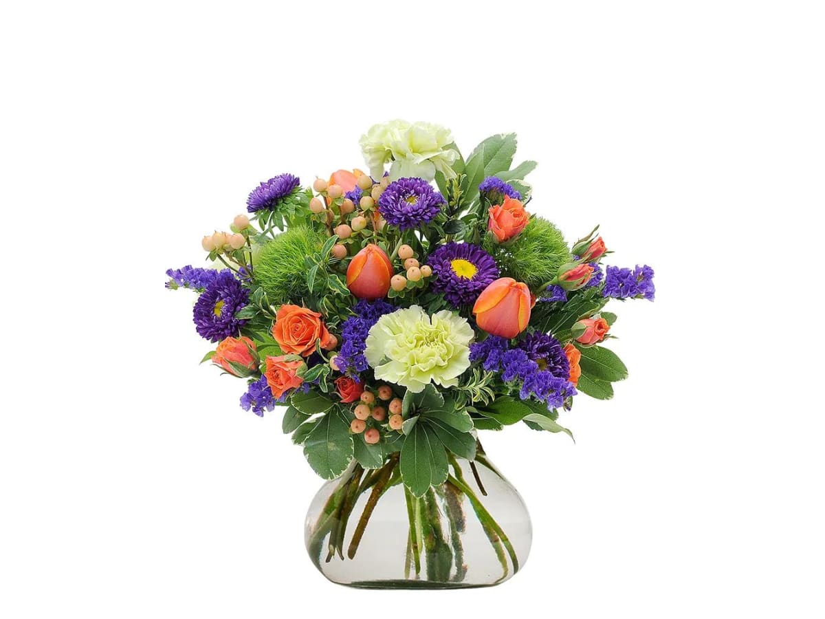 Bouquet of orange and purple flowers in a clear glass vase